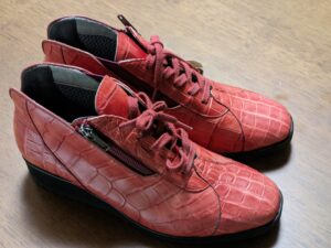 色褪せた赤いクロコダイルレザーの靴