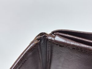 補修前のプラダ財布折り曲げ部の破れ