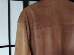 色褪せた修理前のアヴィレックスのレザージャケットの肩の部分