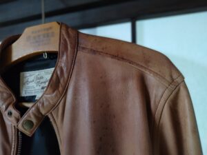 色褪せ、シミのあるアヴィレックスのレザージャケット