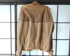 修理前のバーバリーの革ジャケット背面の色褪せ