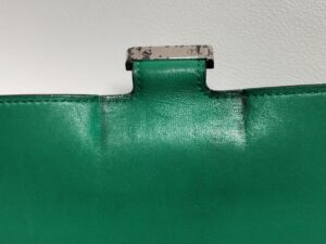 修理前のエルメスコンスタンス長財布の留め金具周辺のヨレ