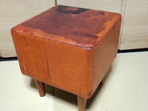 修理前のシミ、割れのある馬革のスツール