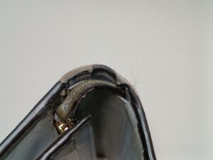 修理前のグッチ財布の折り曲げ部分のコバ破れ