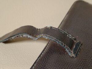 修理前のエルメスベアン長財布の傷んだベルト部分