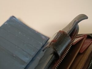 修理前のボッテガ・ヴェネタ2つ折り財布のベルト革のひび割れ