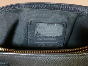 修理前のコーチバッグ内側の劣化した合皮のタグ