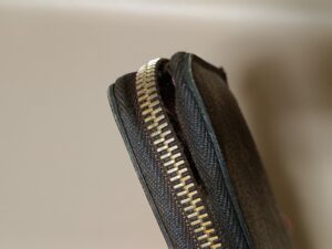 修理前のルイ・ヴィトンモノグラム財布のファスナーテープの破れ