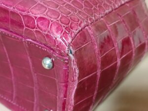 修理前のクロコダイルレザーのバッグコーナーの破れ